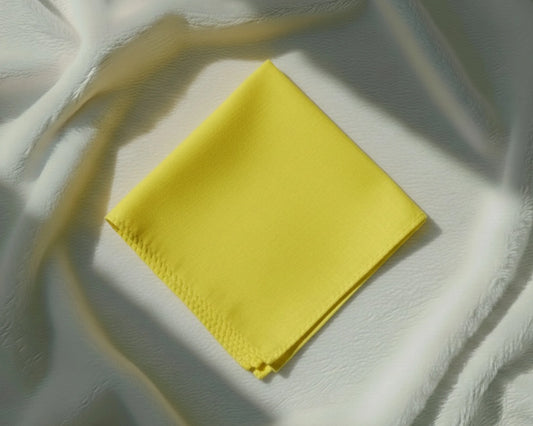 Yellow fabric square on a textured white surface