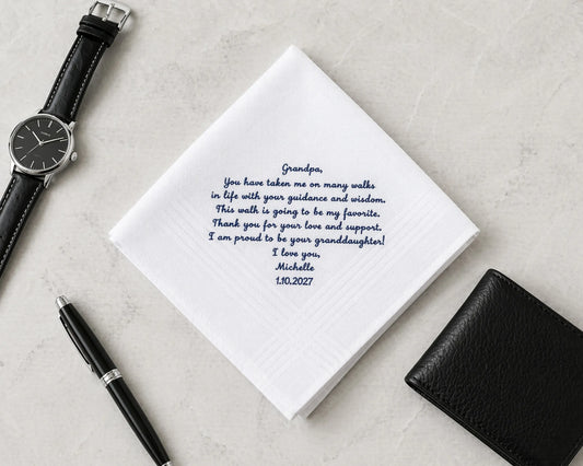 Notebook with a heartfelt message, pen, wallet, and watch on a light gray surface