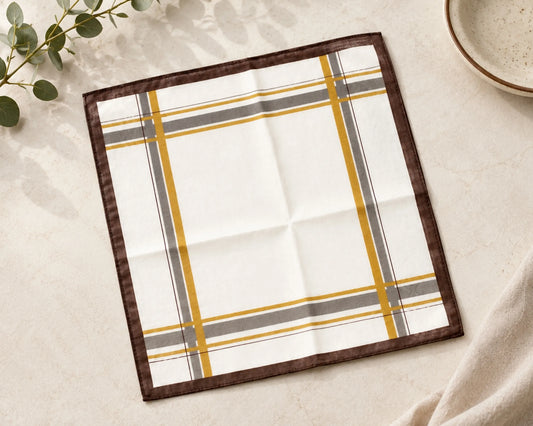 Plaid hanky with brown, yellow, and gray pattern on a light surface.