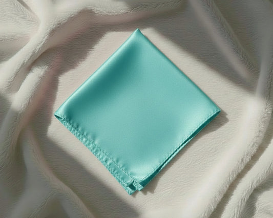 Turquoise fabric square on a textured beige surface