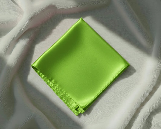 Green satin pocket square on a textured white surface