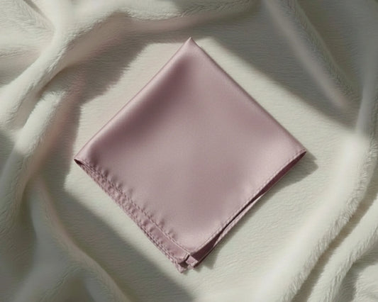 Folded pink fabric on a textured white surface