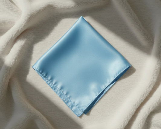 Light blue satin pocket square on a textured beige fabric background
