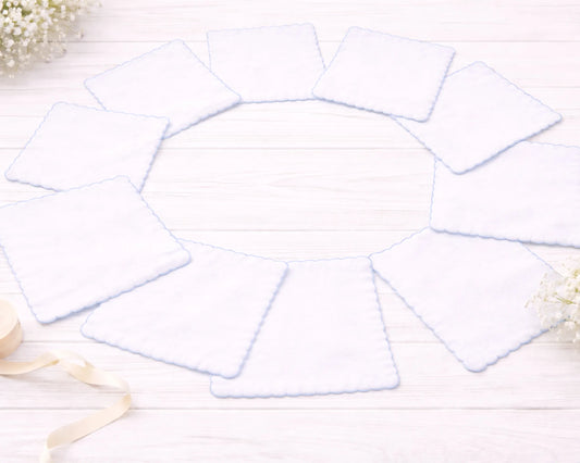 Set of white hanky on a light wooden surface with decorative elements.