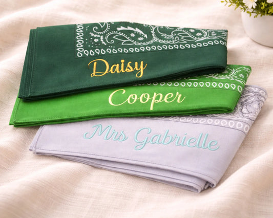 Three folded bandanas with embroidered names on a light background