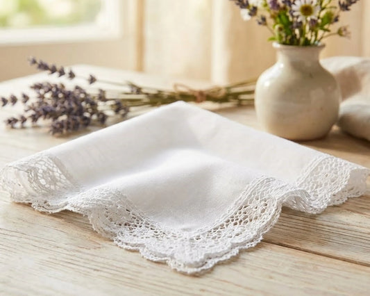 White lace handkerchief on a wooden surface with a vase of flowers in the background
