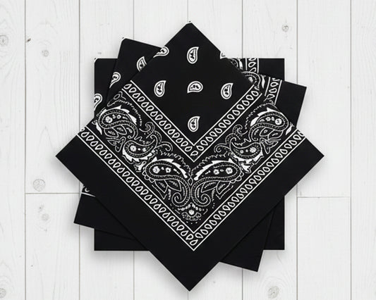 Stack of folded black cotton bandanas with white paisley prints