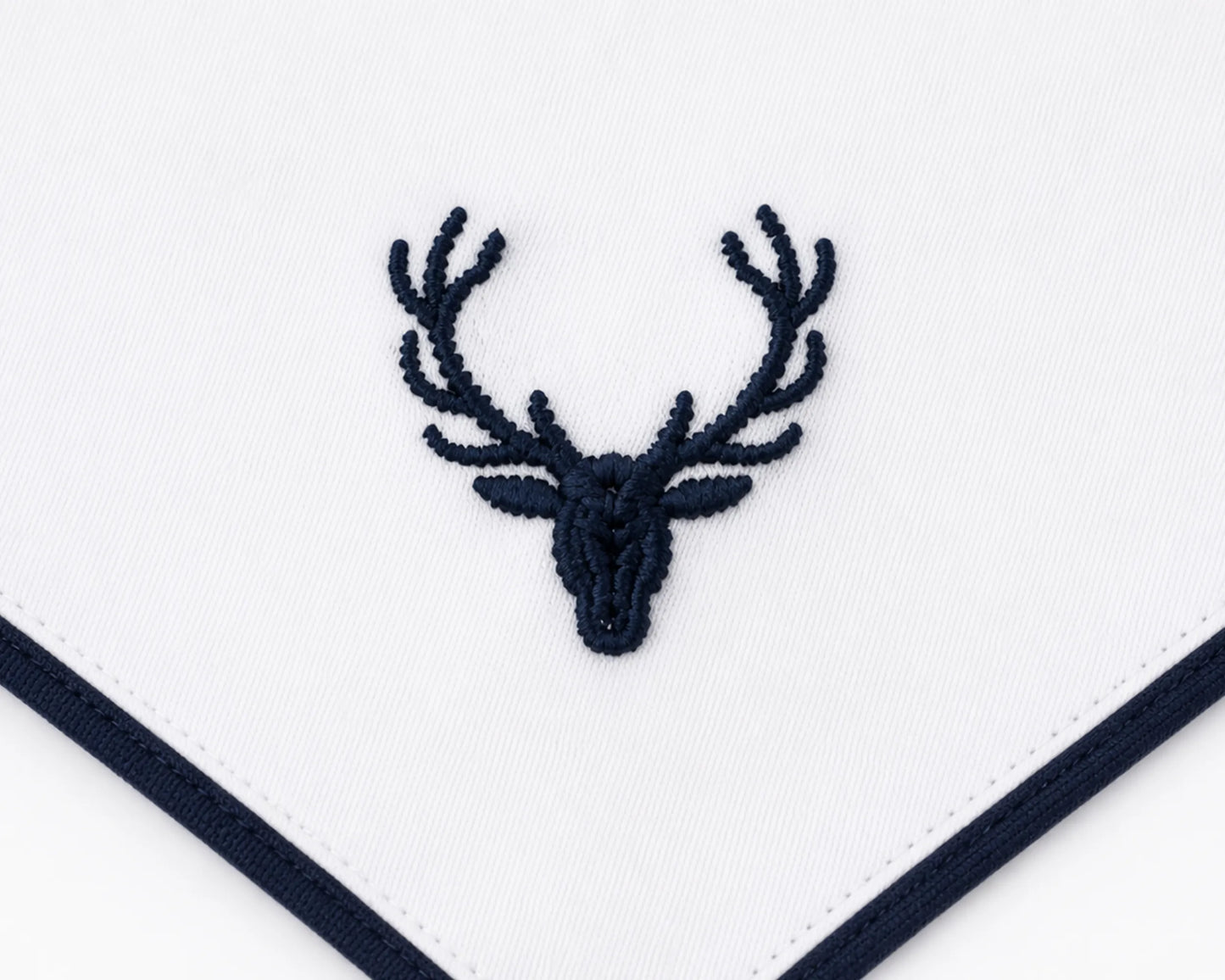 Embroidered deer head design on a white fabric with navy border