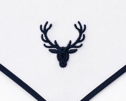 Embroidered deer head design on a white fabric with navy border