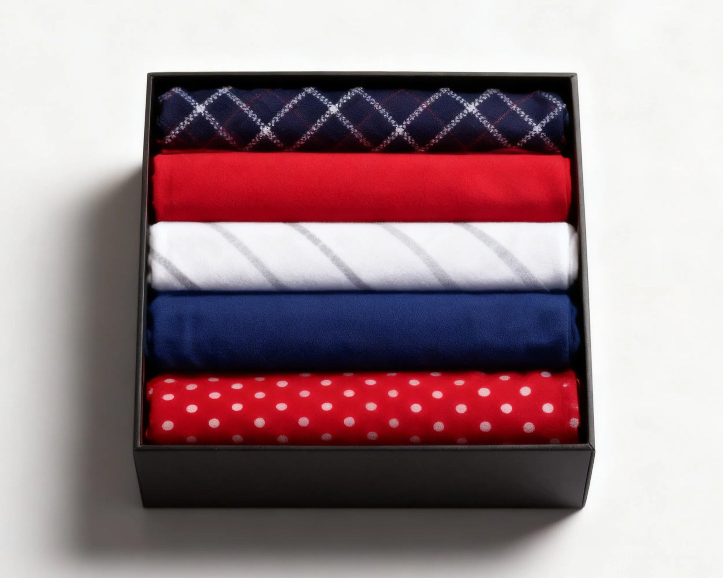 Navy checkered and red polka dot hanky on a white marble surface