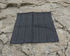 Black checkered hanky on a stone surface