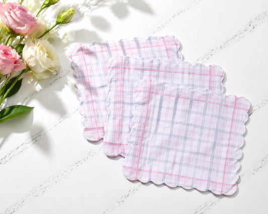three checkered hanky coasters on a white surface with flowers in the background