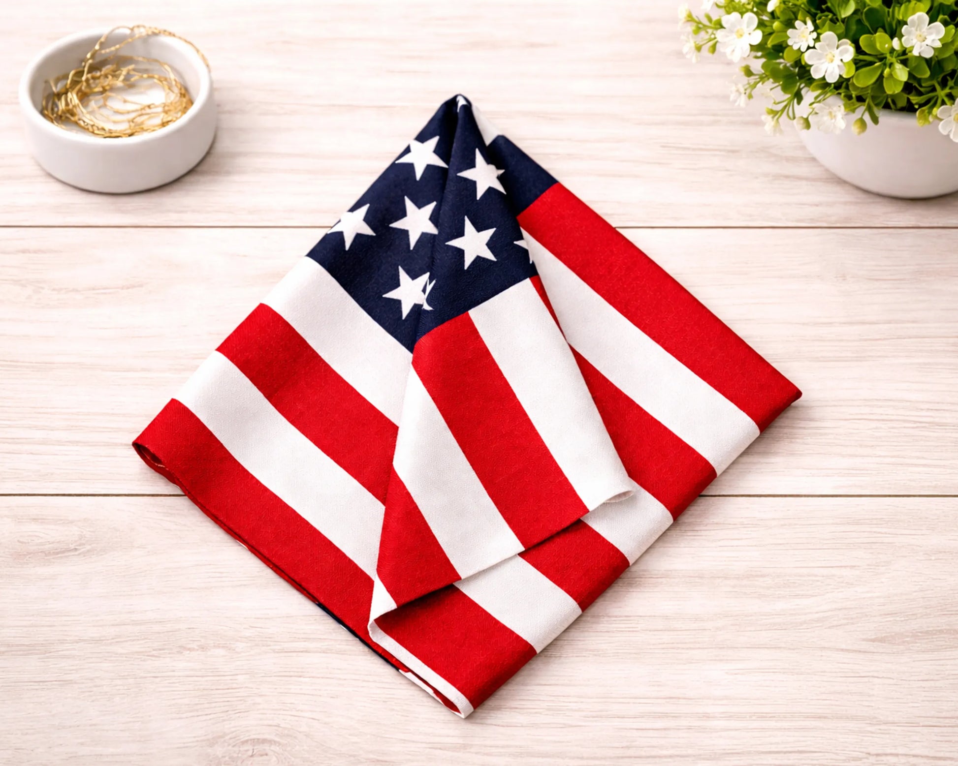 American flag napkin on a wooden table with a bowl and flowers in the background