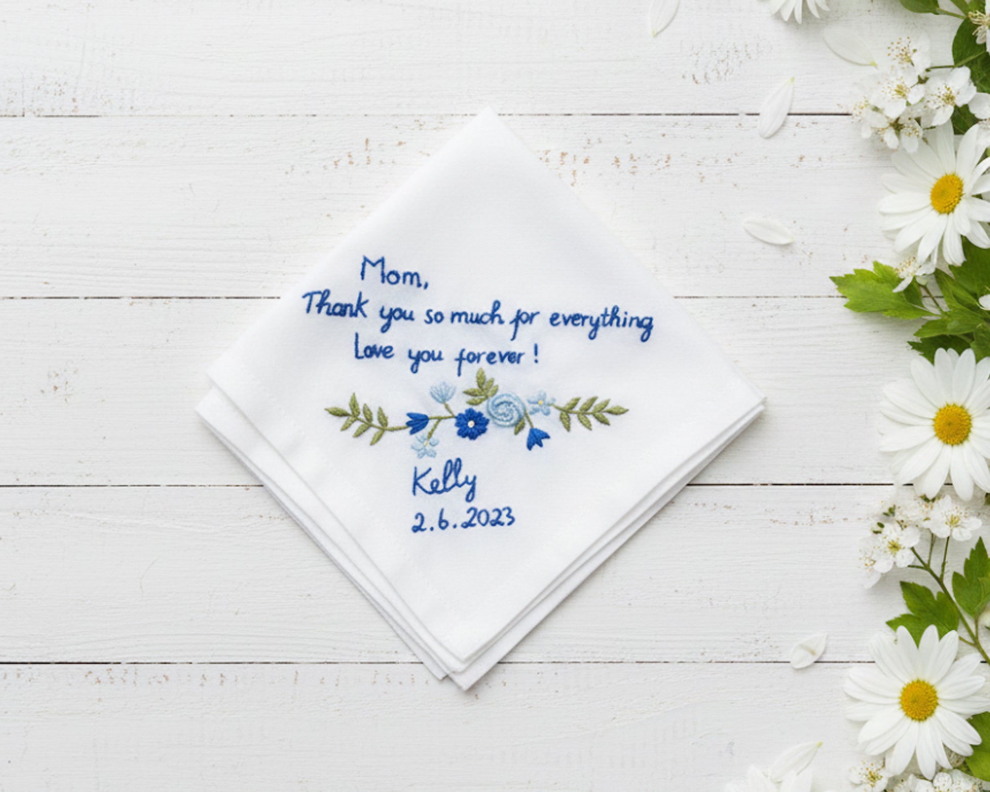 White cotton handkerchief featuring blue floral vine embroidery and a personalized thank you message for mom