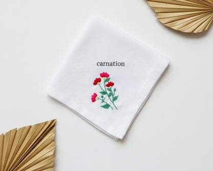 Pure white cotton handkerchief featuring a centered red carnation embroidery with green stems on a neutral background