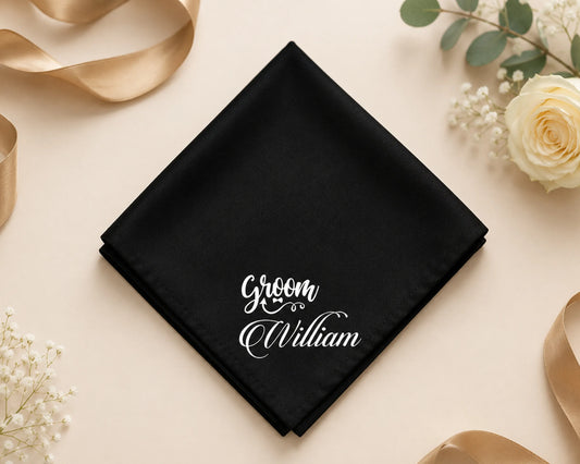 Black hanky with 'Groom William' text on a decorative background with flowers and ribbons.
