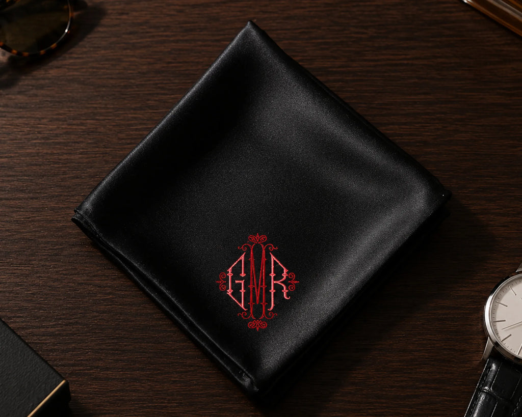 Black satin hanky with red monogram on a wooden surface