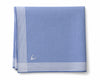 Blue napkin with white stripes and a small emblem on a white background
