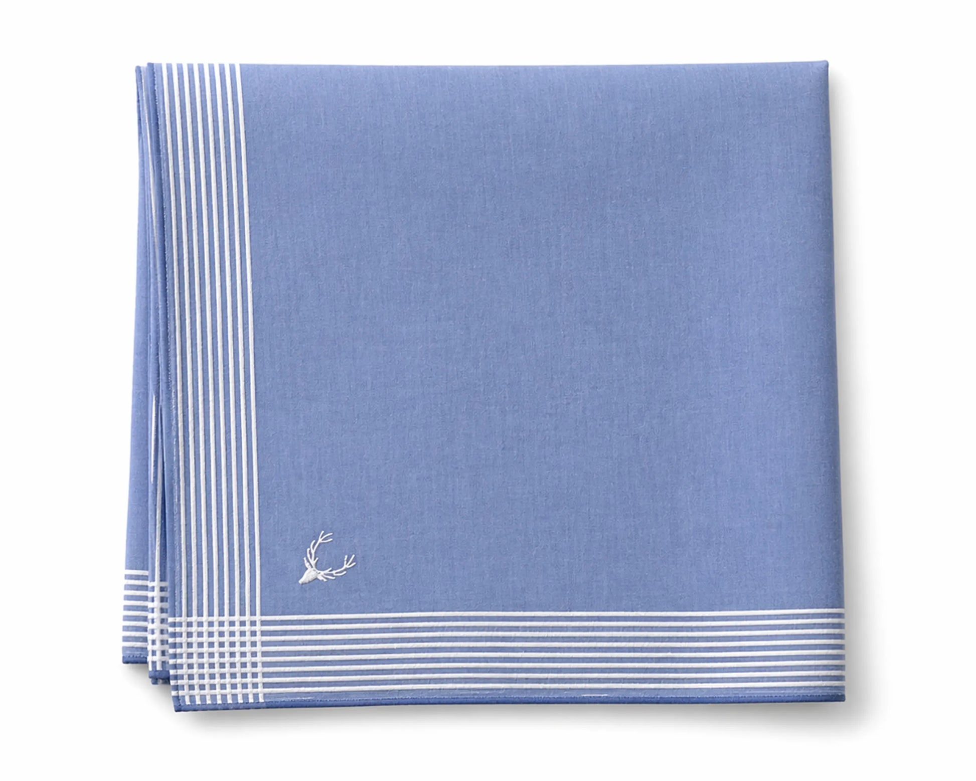 Blue napkin with white stripes and a small emblem on a white background