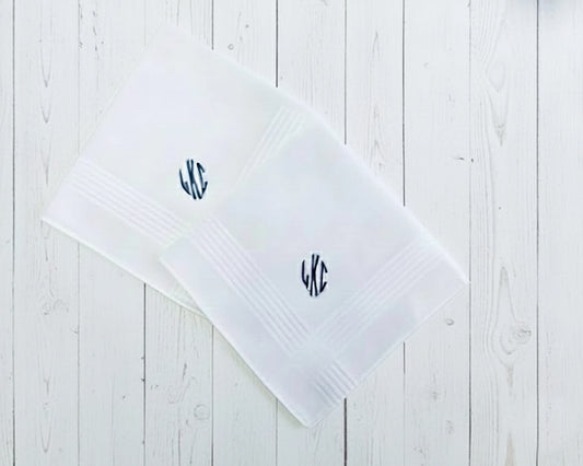Single white cotton handkerchief with a copper-orange circular monogram PBR on a dark textured surface