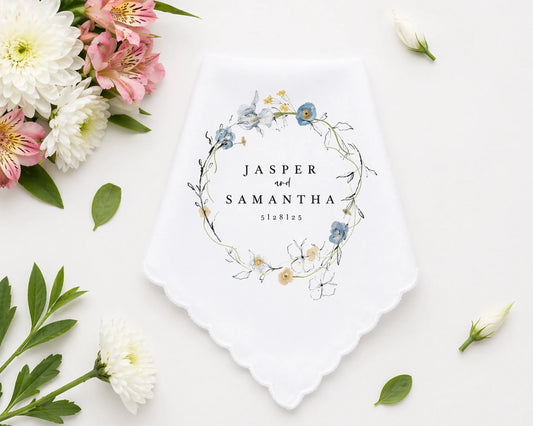 Checkered handkerchief with pink border on a white surface with flowers and leaves.