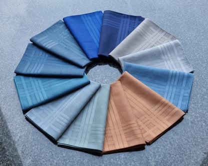 Circular arrangement of folded hanky  in various blue tones on a textured gray background
