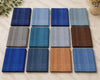 Collection of various blue and brown fabric hanky on a light surface.