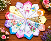Colorful handkerchiefs with floral patterns arranged in a circular pattern on a wooden surface.