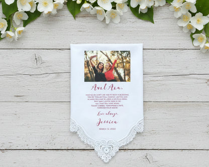 Lace Handkerchief with custom message surrounded by pink flowers on a light wooden surface