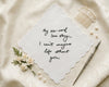 Decorative hanky with six-word love story on a textured surface with flowers and a comb.