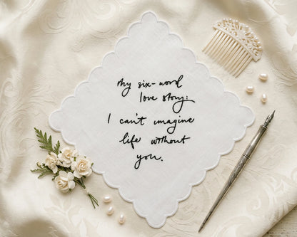 Decorative hanky with six-word love story on a textured surface with flowers and a comb.