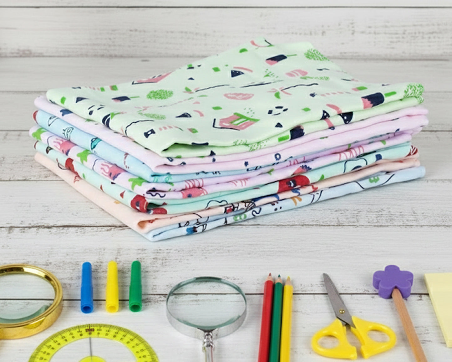 Folded stack of soft cotton hankerchiefs for boys and girls with whimsical green and pink designs
