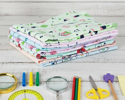 Folded stack of soft cotton hankerchiefs for boys and girls with whimsical green and pink designs