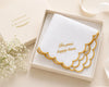 Embroidered handkerchief with 'For your happy tears' text in a decorative box on a light background.