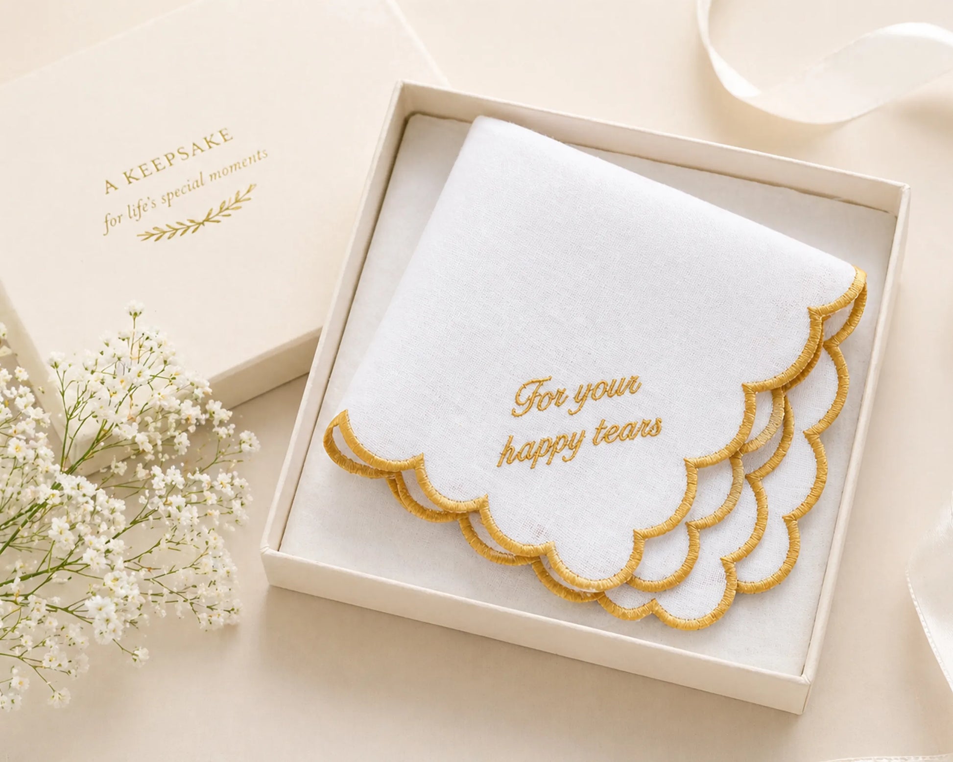 Embroidered handkerchief with 'For your happy tears' text in a decorative box on a light background.