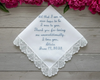 Embroidered handkerchief with personalized message on a wooden surface with pink flowers.