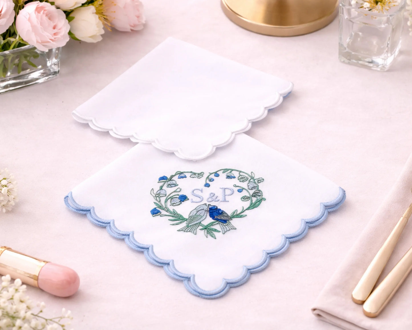 Embroidered handkerchief with floral design and initials on a light surface.