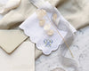 Embroidered handkerchief with floral design and monogram on marble surface