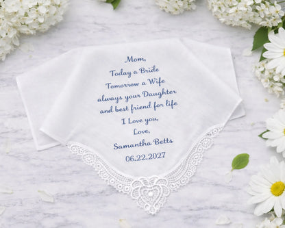 Embroidered handkerchief with personalized message on a marble surface with flowers.
