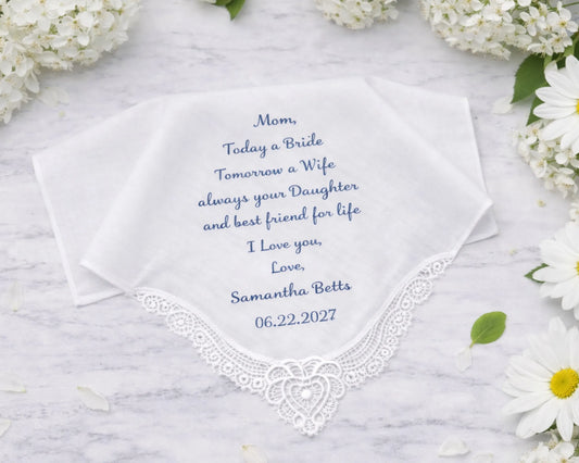 Embroidered handkerchief with personalized message on a marble surface with flowers.