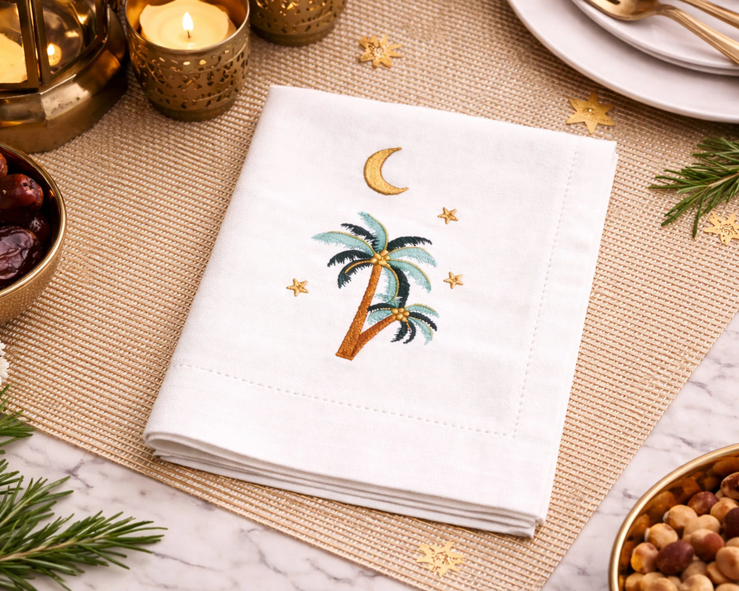 Embroidered napkin with palm tree and moon design on a decorative table setting.