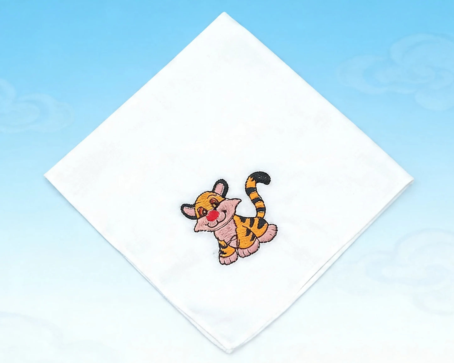 Embroidered patch of a cartoon tiger on a white fabric square with a blue background
