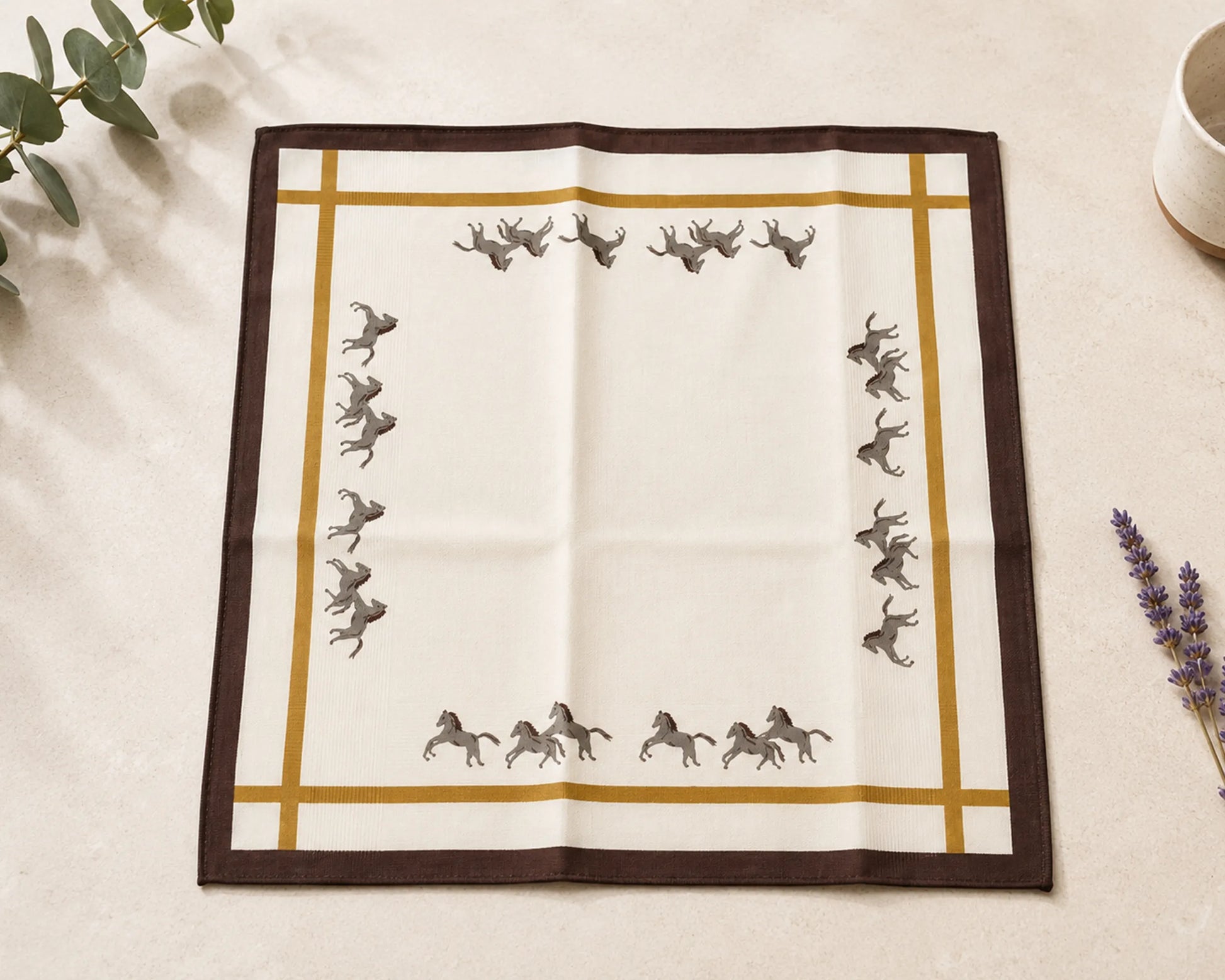 Fabric square with horse pattern on a beige surface