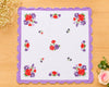 Floral printed hanky  on a wooden surface with decorative elements.