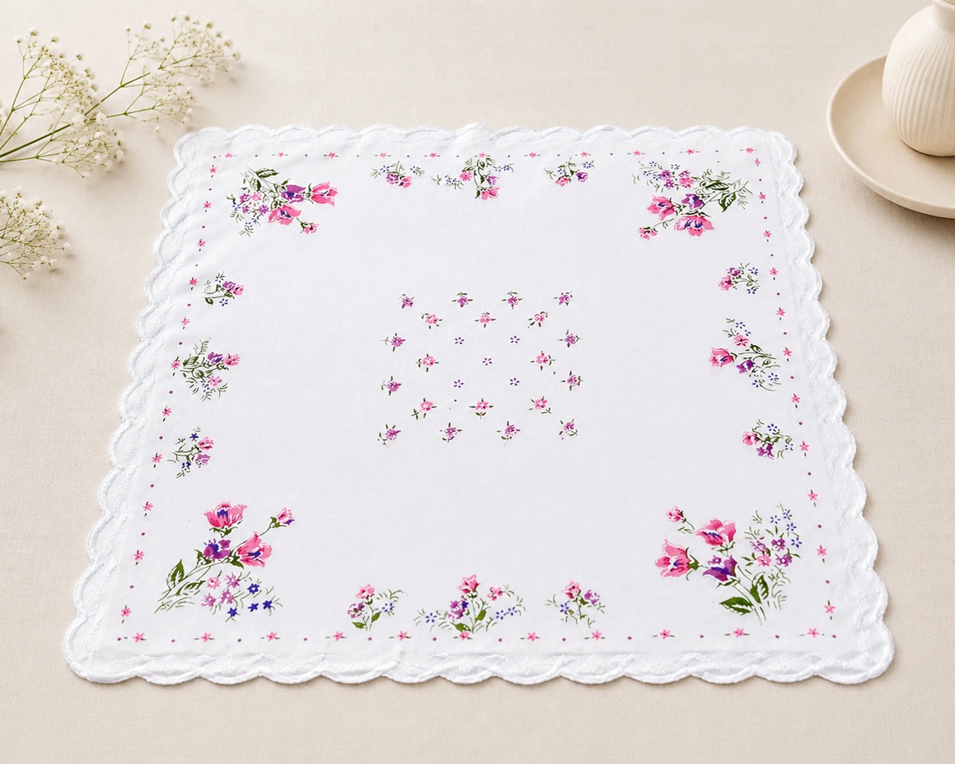 Floral-patterned handkerchief on a beige surface with decorative elements.