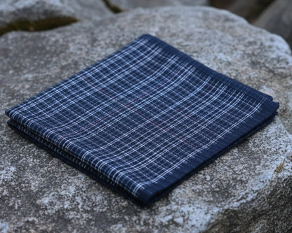 Folded blue plaid fabric on a stone surface