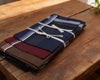 Folded fabric pieces with striped patterns tied together on a wooden surface