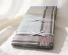 Folded fabric with plaid pattern tied with a white ribbon on a white background