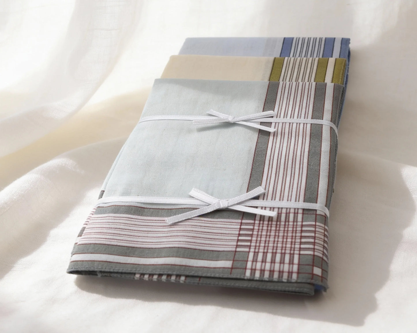 Folded fabric with plaid pattern tied with a white ribbon on a white background