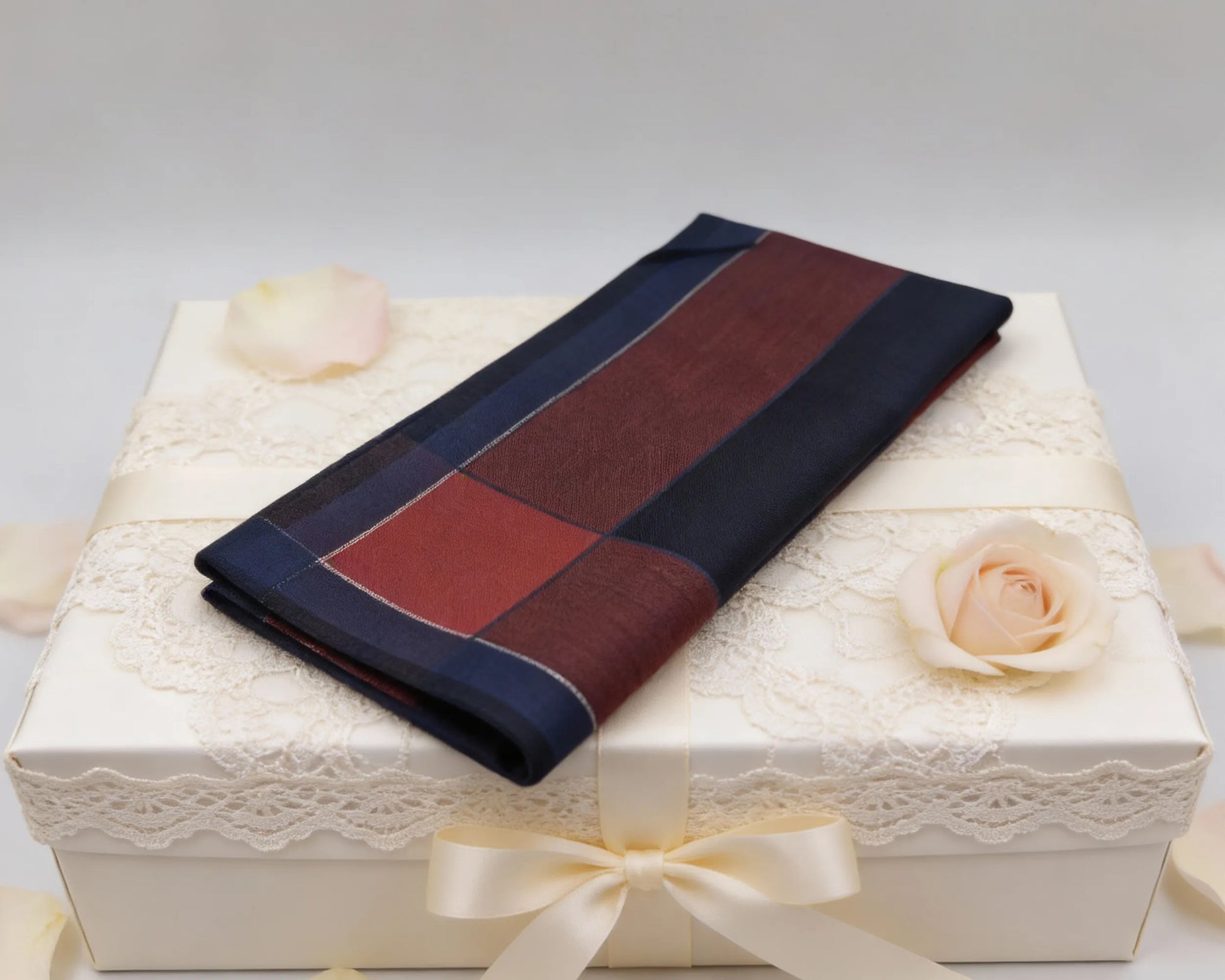Folded fabric with blue and red stripes on a decorative box with flowers.